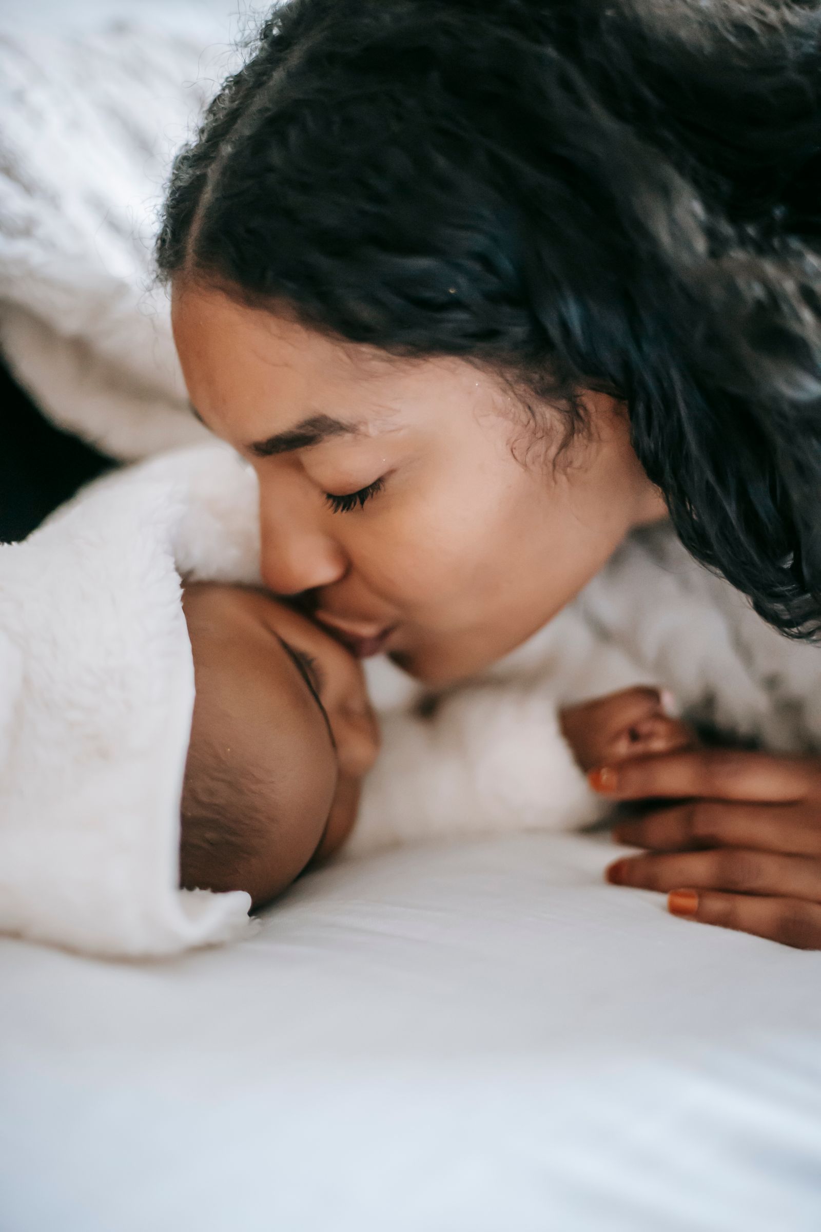 A Black mother holds her newborn close. Knowing the postpartum warning signs keeps new mothers safe in the weeks after birth.