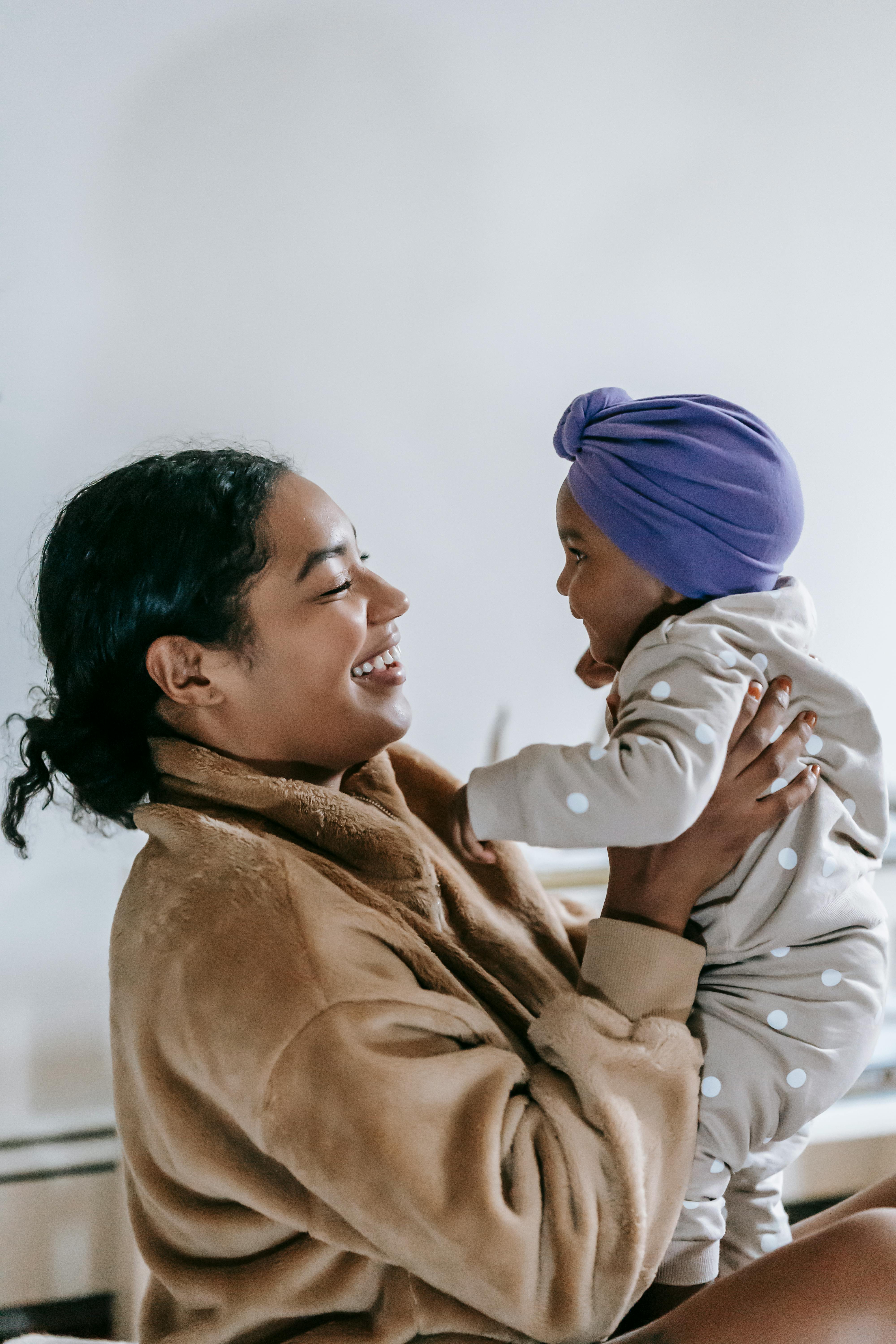 cheerful black mother with little baby