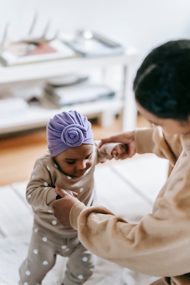 Mother Helping Her Baby Girl To Walk