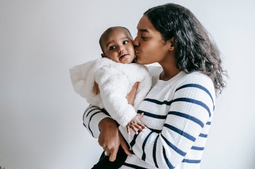 Free Mother Kissing Her Cute Baby Stock Photo