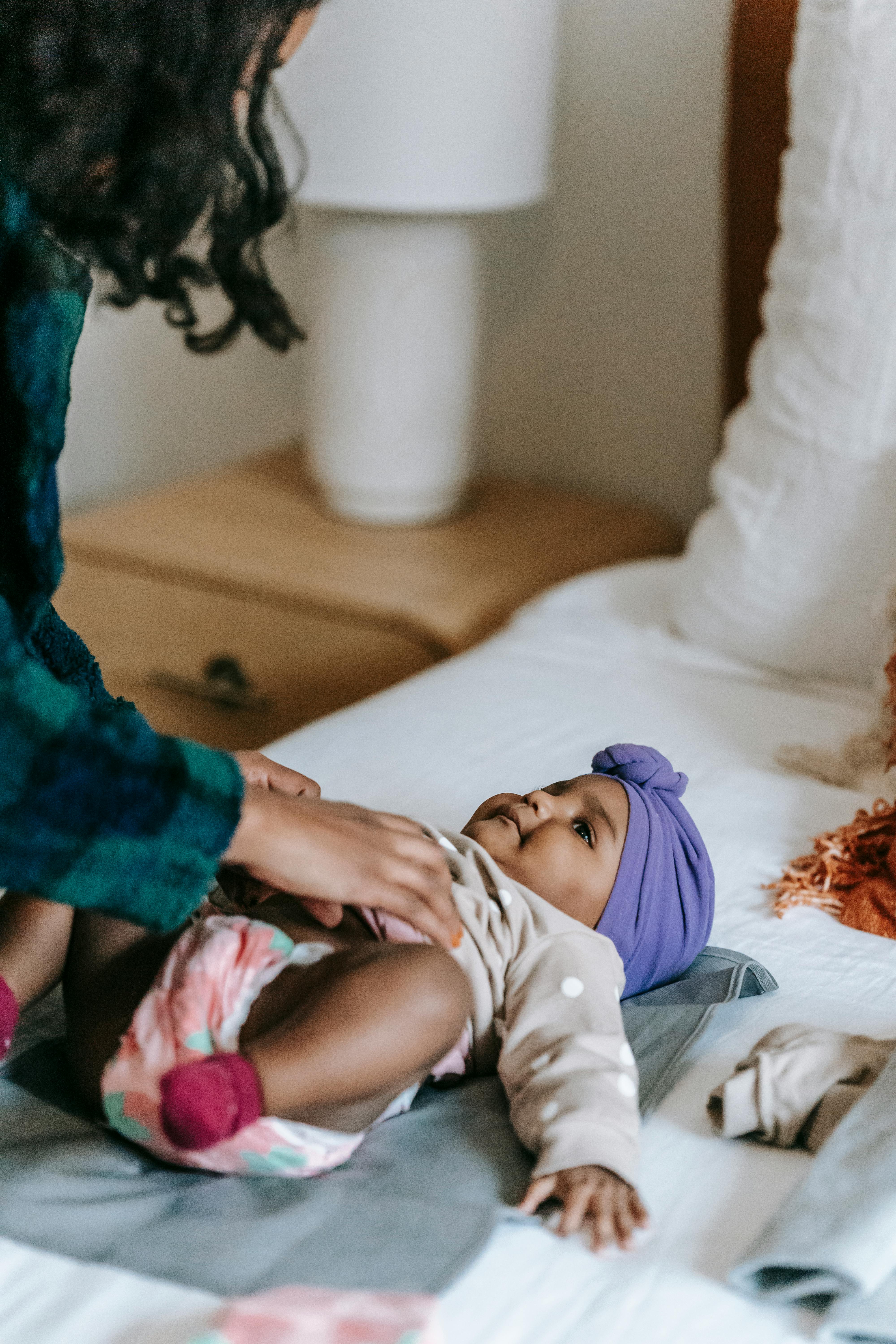 crop black mother with baby on bed