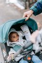 Crop parents with black child in baby carriage