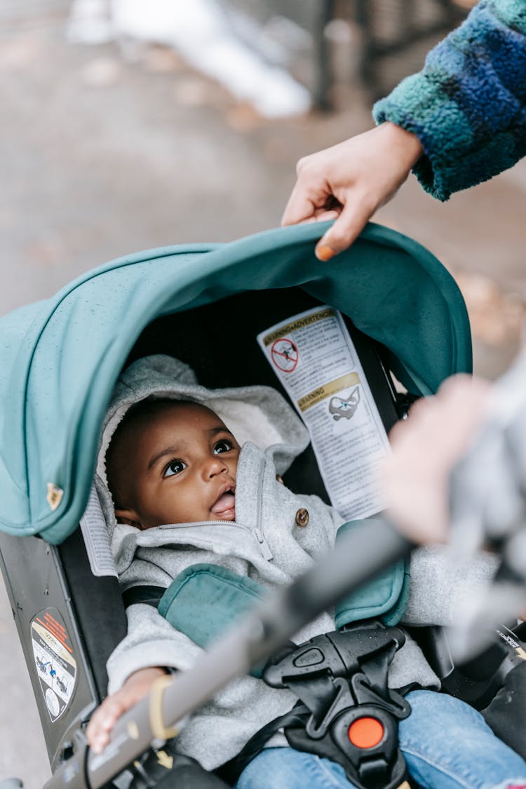 Crop Parents With Black Child In Baby Carriage