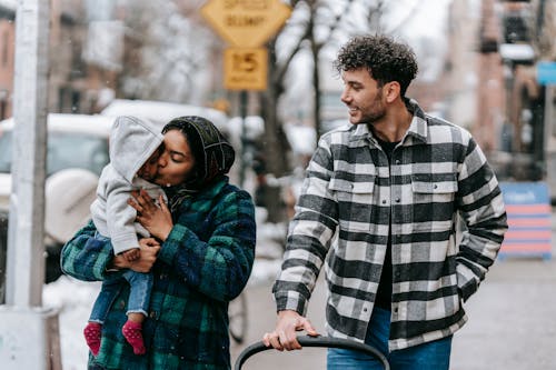 Free Tender multiracial family walking on street with black baby Stock Photo