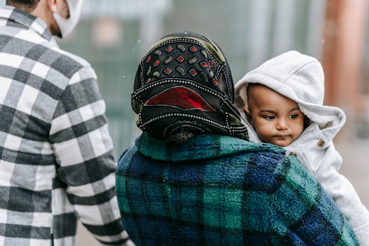 Unrecognizable Parent With Black Baby On Street