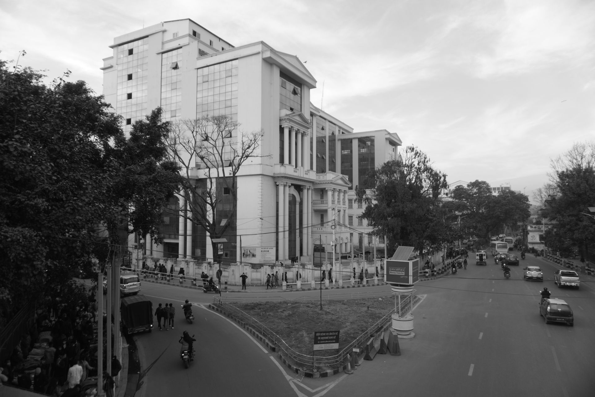 Grayscale image of a bustling street scene in Kathmandu, Nepal with architecture and vehicles.