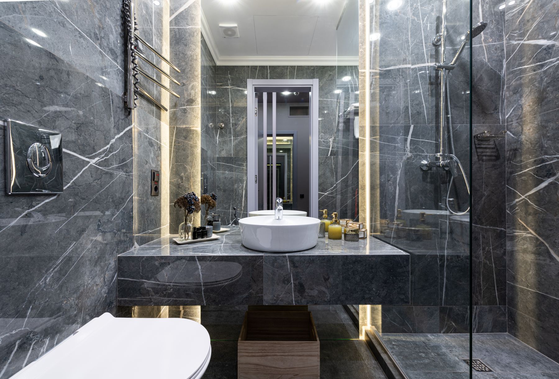 Contemporary bathroom with black tiled shower, glass enclosure and white sink