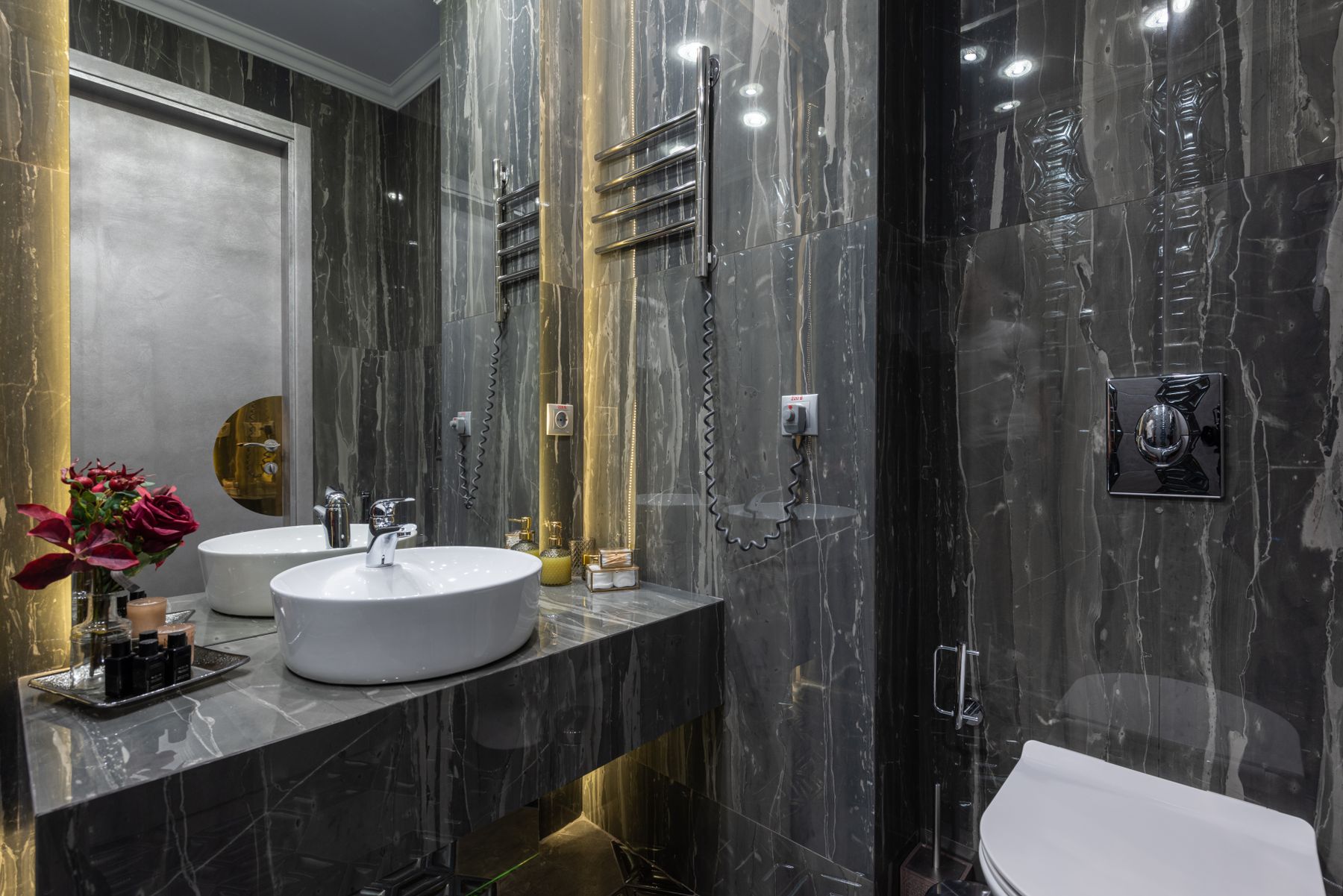 Modern black bathroom with tiled walls, sink and large mirror
