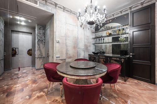 Free Interior of modern spacious kitchen with round table and red chairs placed near contemporary counter with kitchenware in stylish apartment Stock Photo