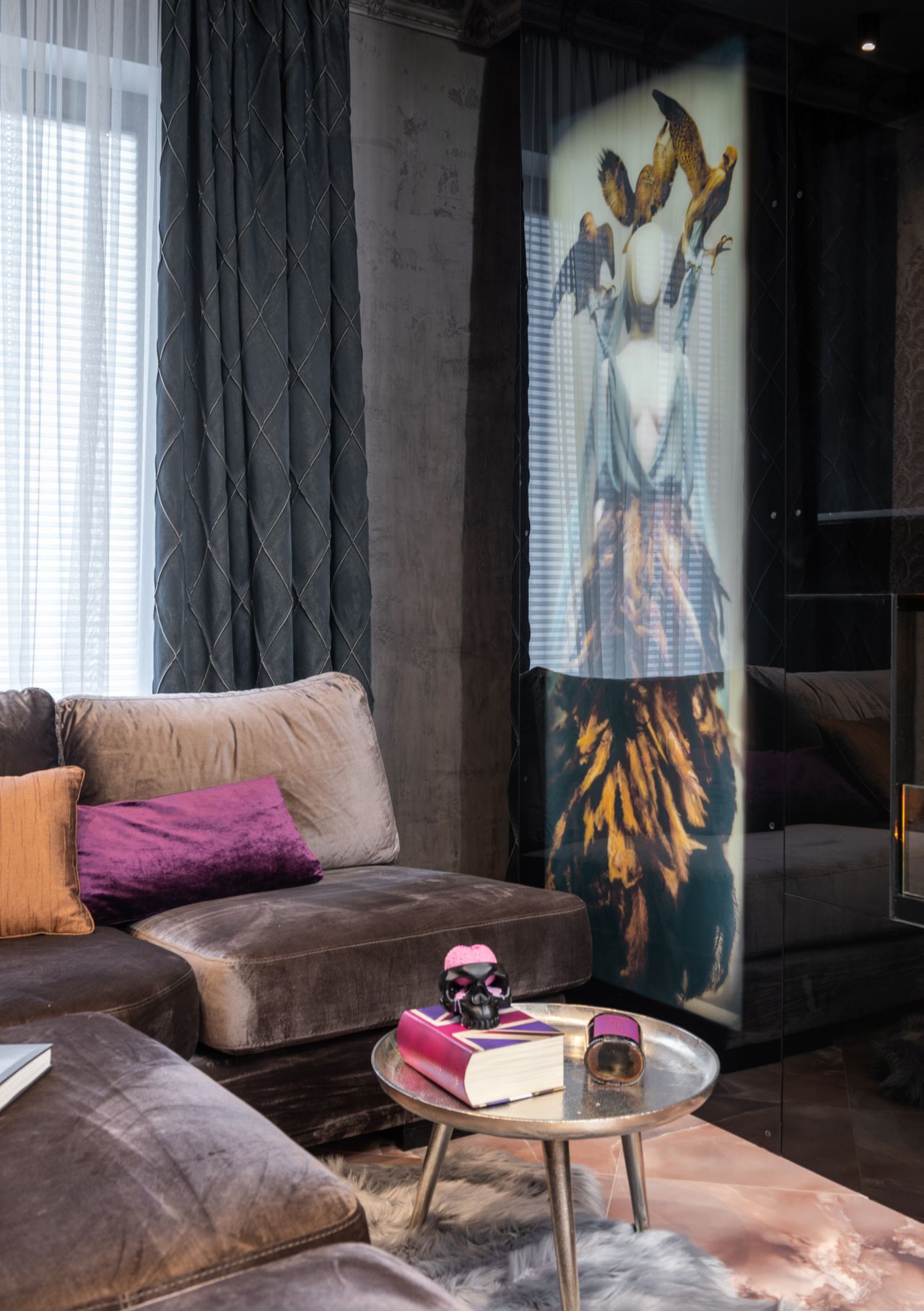 Moody living room with a chocolate brown velvet sofa, jewel-tone pillows, and dramatic wall art