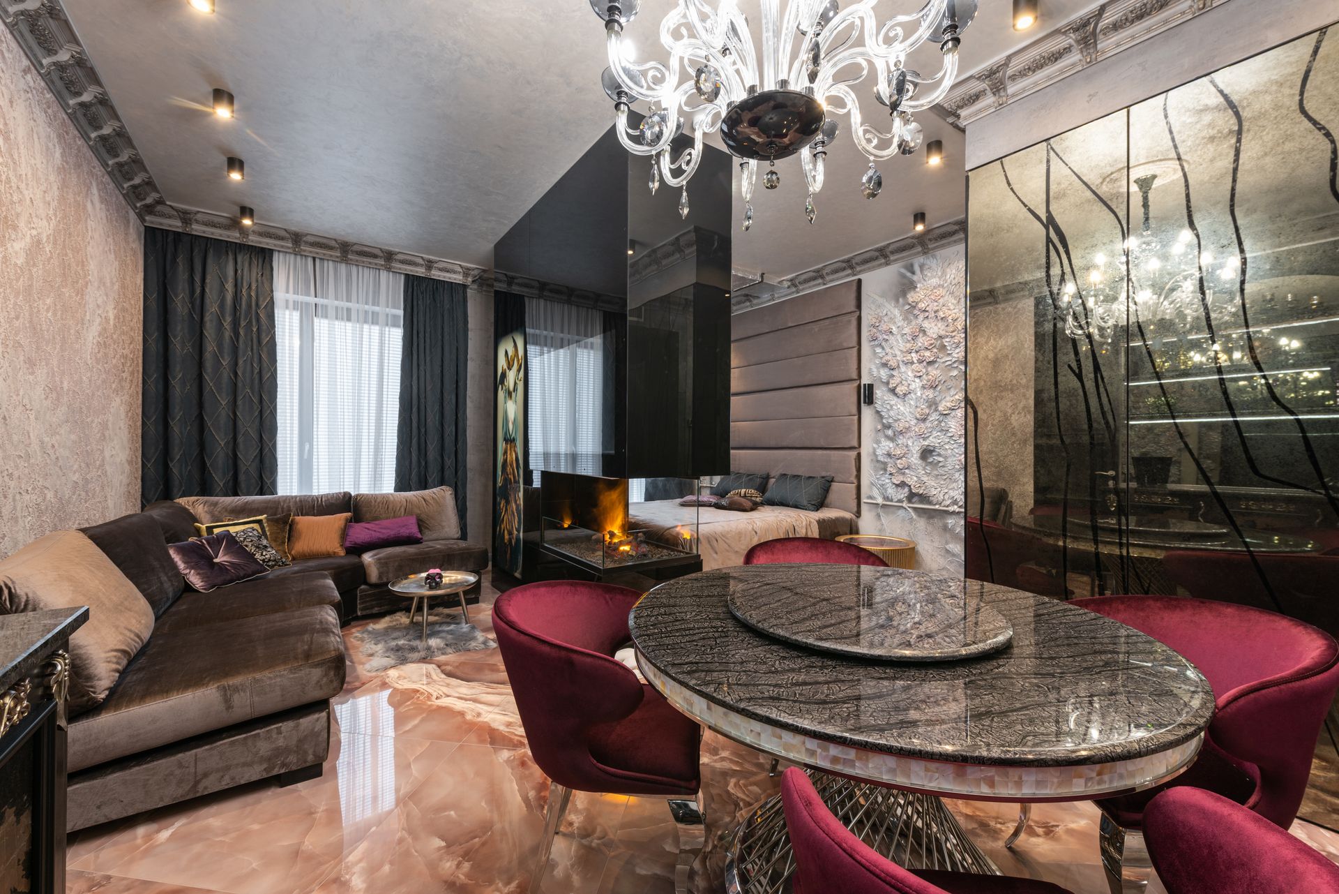 Elegant modern living room with stylish decor, fireplace, and opulent chandelier enhancing the cozy atmosphere.