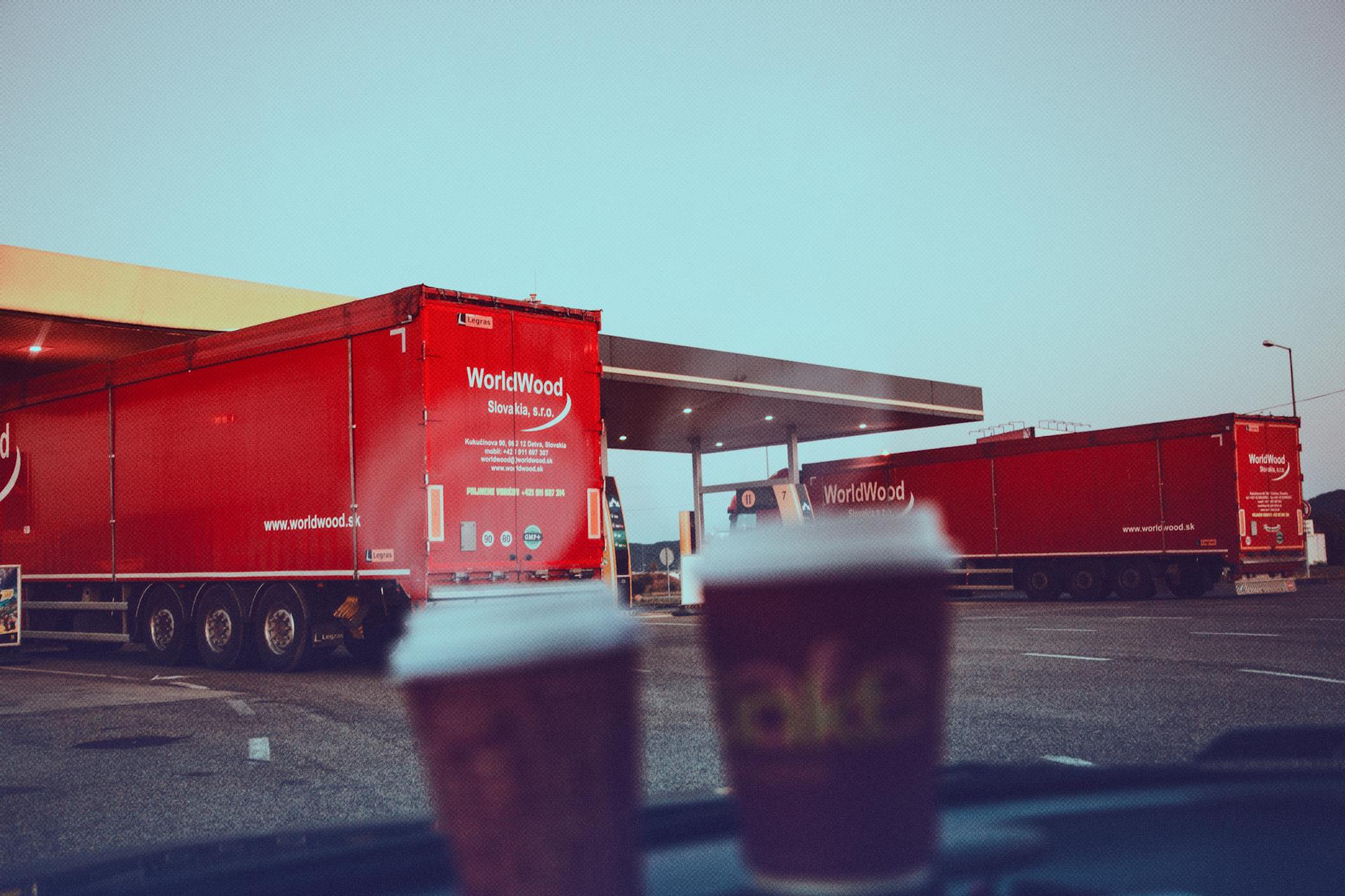 Cargo trucks at a Slovakian gas station highlight logistics and travel during dawn.