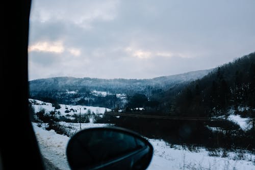 Vista desde dentro de un automóvil pasando por un paisaje nevoso.