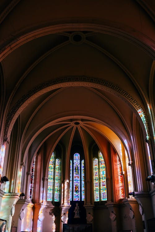 Interior design of historic cathedral dome with arched ceiling and leaded glass windows in sunlight