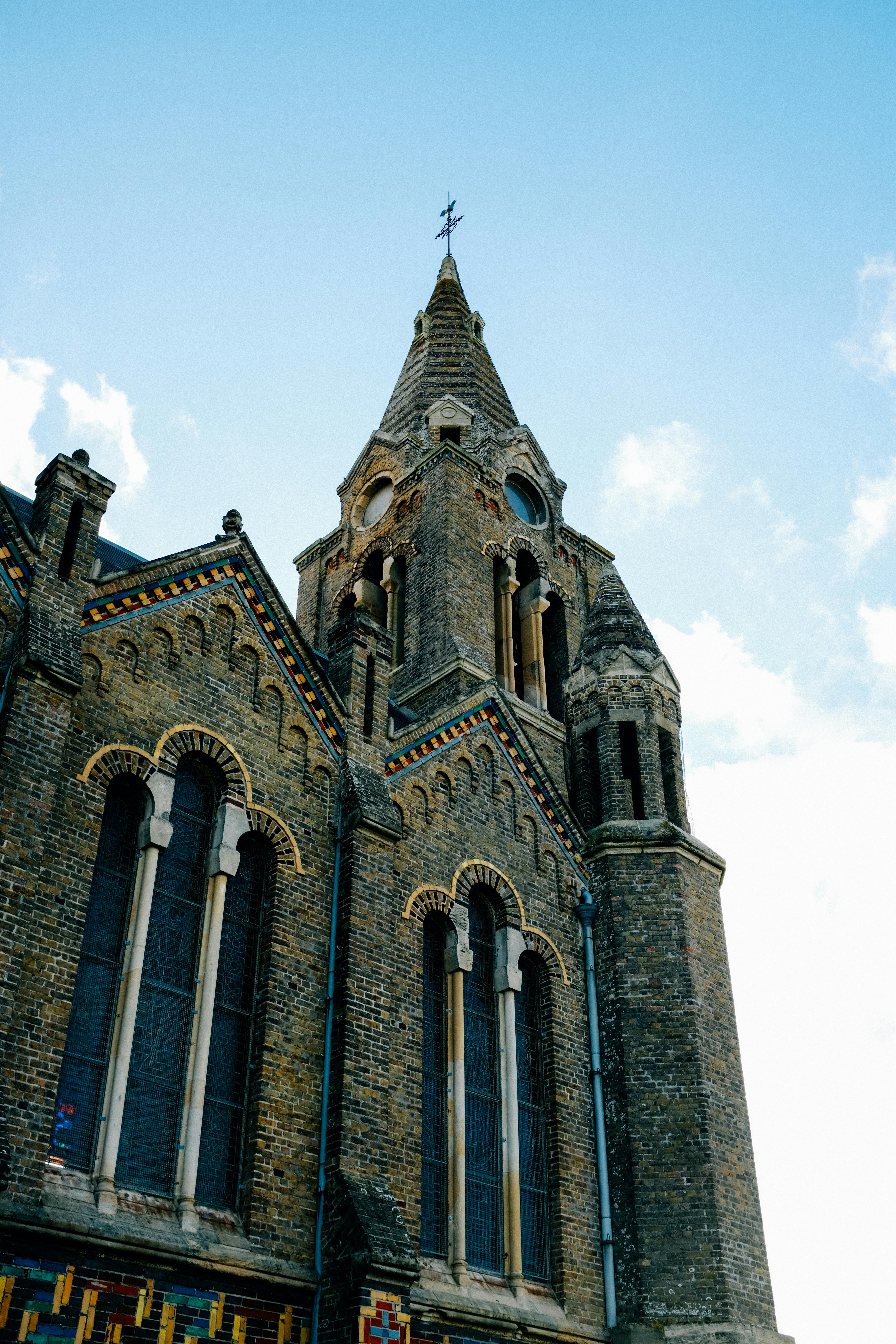 From below exterior of majestic historic church with ornamental details windows and rood on spire top