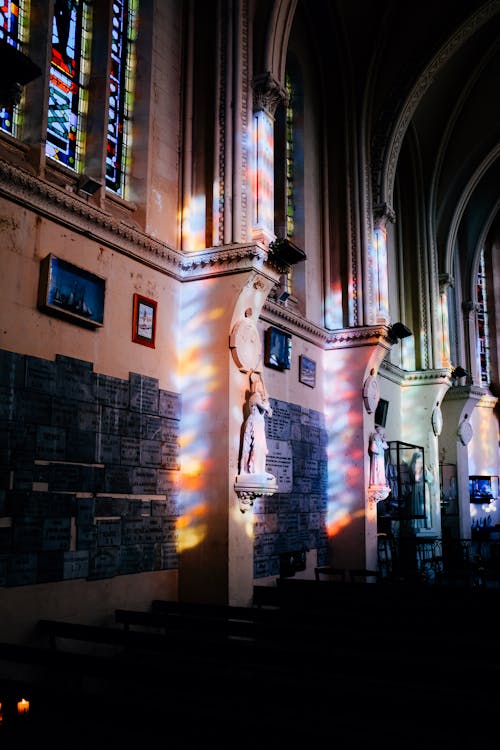 Interior of historic church with leaded glass windows arched ceilings and paintings on walls