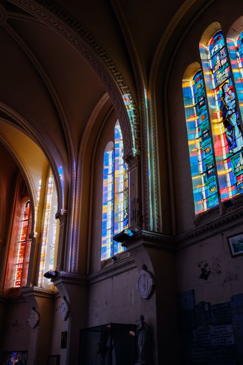 Free Ornamental Catholic church walls and leaded glass windows under arched ceiling in sunlight Stock Photo