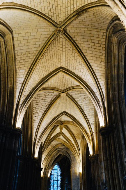 From below of majestic catholic cathedral with tall geometrical ceiling and large windows