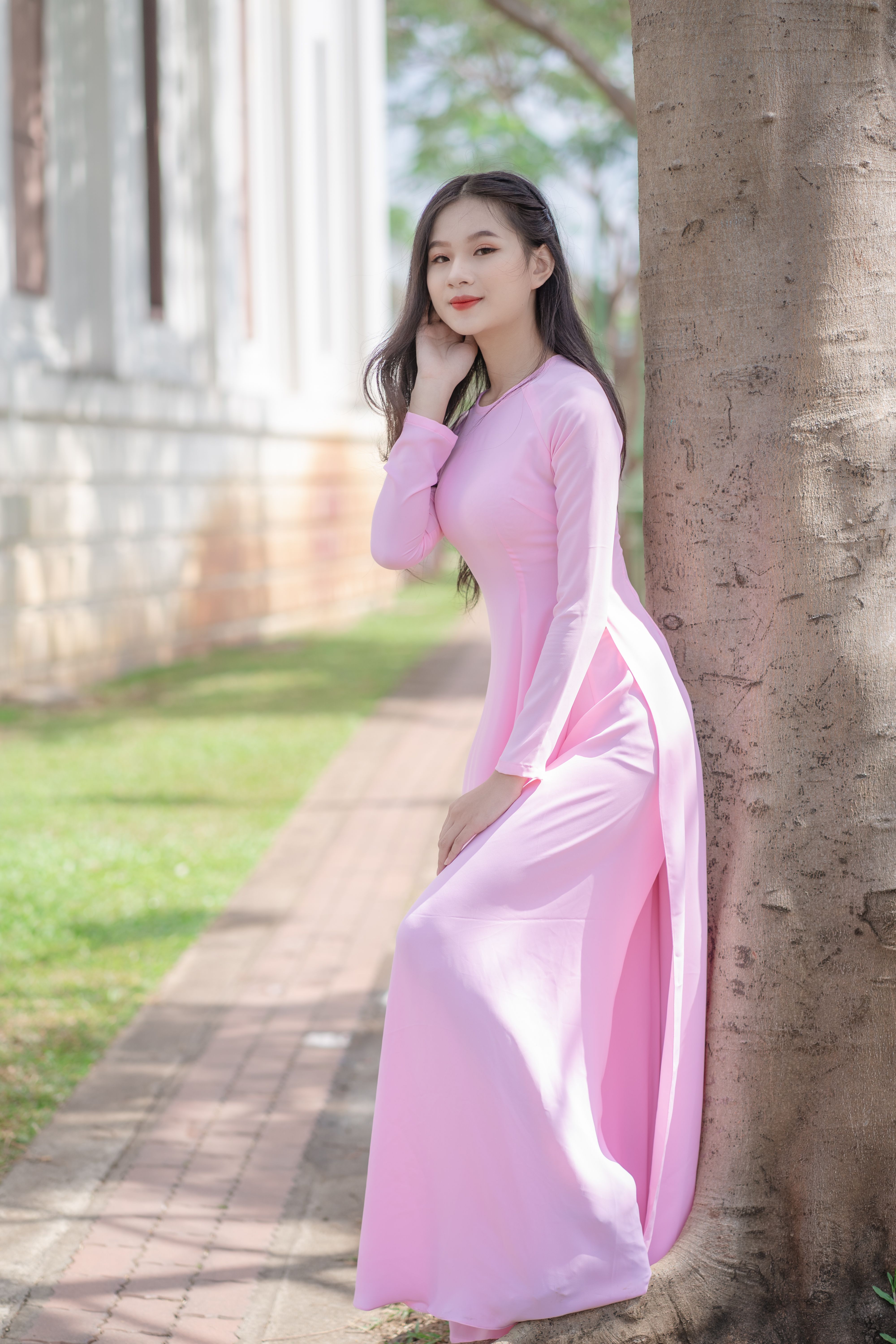 A Woman Standing Beside a Tree Trunk · Free Stock Photo