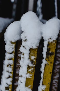 Close-up view of snow-covered metal bars showcasing winter texture and contrast.