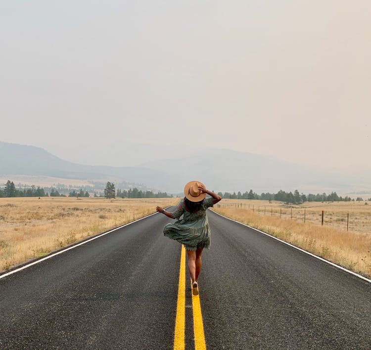 Woman Standing In The Middle Of Country Road