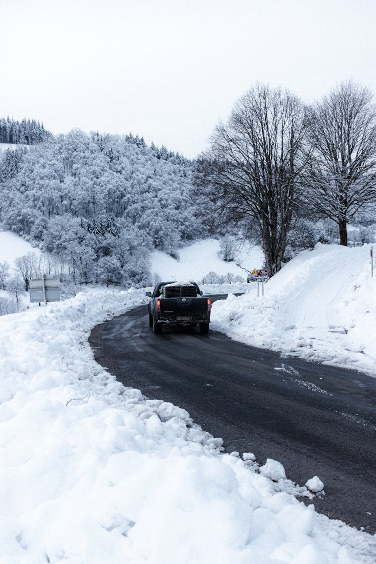 Car Driving On Asphalt Road Near Winter Forest