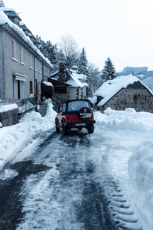 Car parked near houses on snowy road