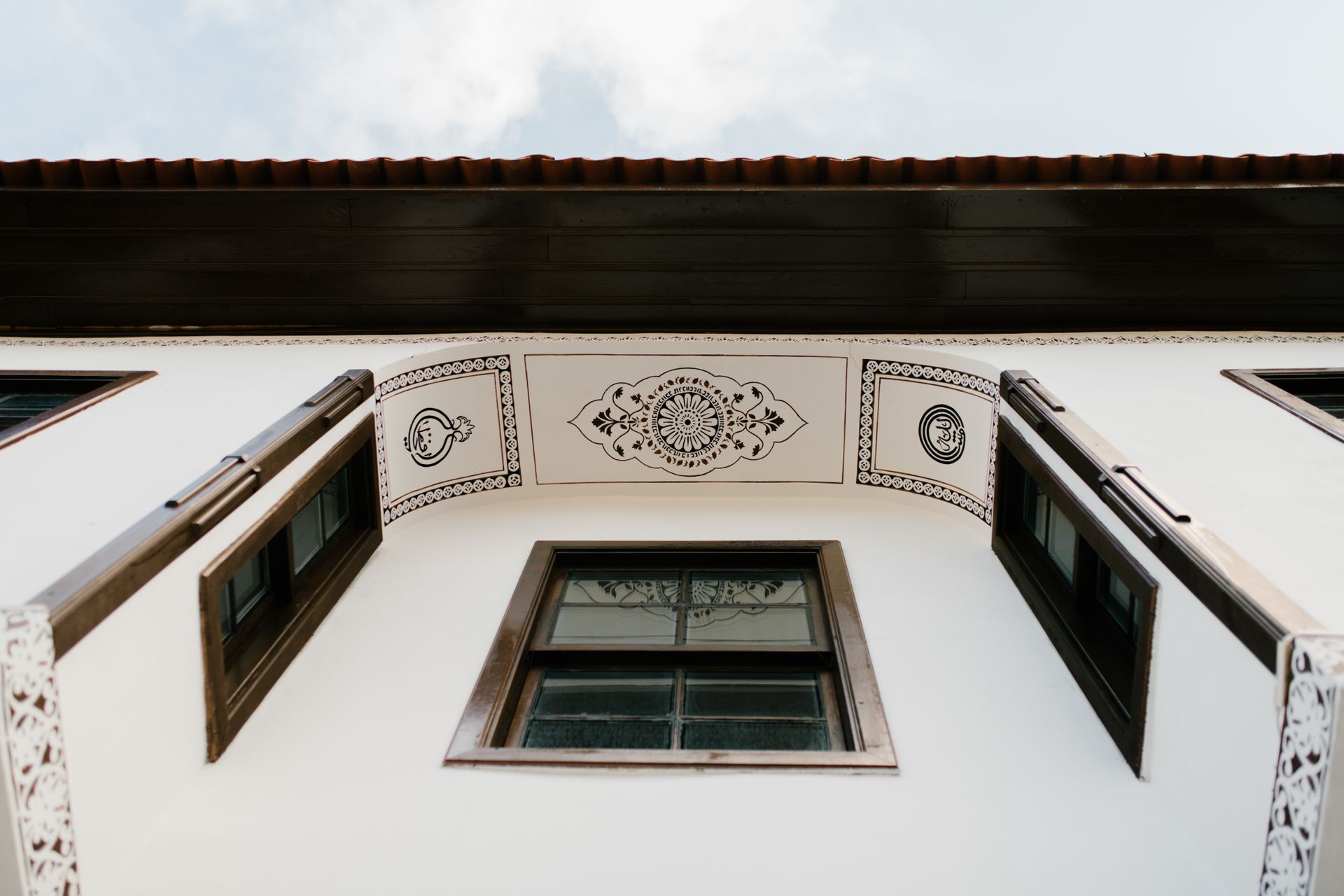 Low angle view of a building with intricate architectural design featuring wooden and glass elements.