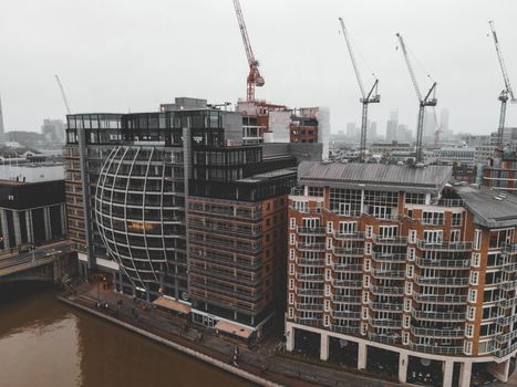 Aerial view of modern buildings and cranes in London, showcasing urban development.