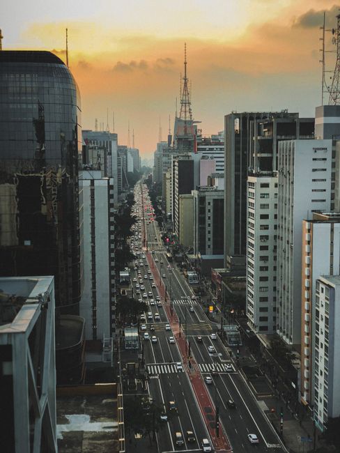 Discover the stunning aerial view of a vibrant city avenue lined with skyscrapers during sunset. Ideal for urban lifestyle content.