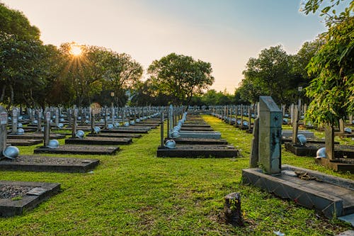 National main heroes cemetery with abundance of tombstones with military hardhats located in national cemetery with green trees in Kalibata