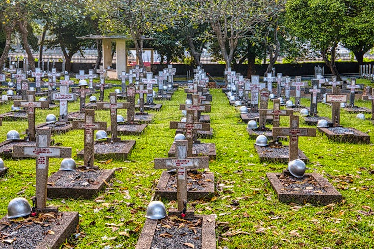 Cemetery With Hardhats On Military Gravestones