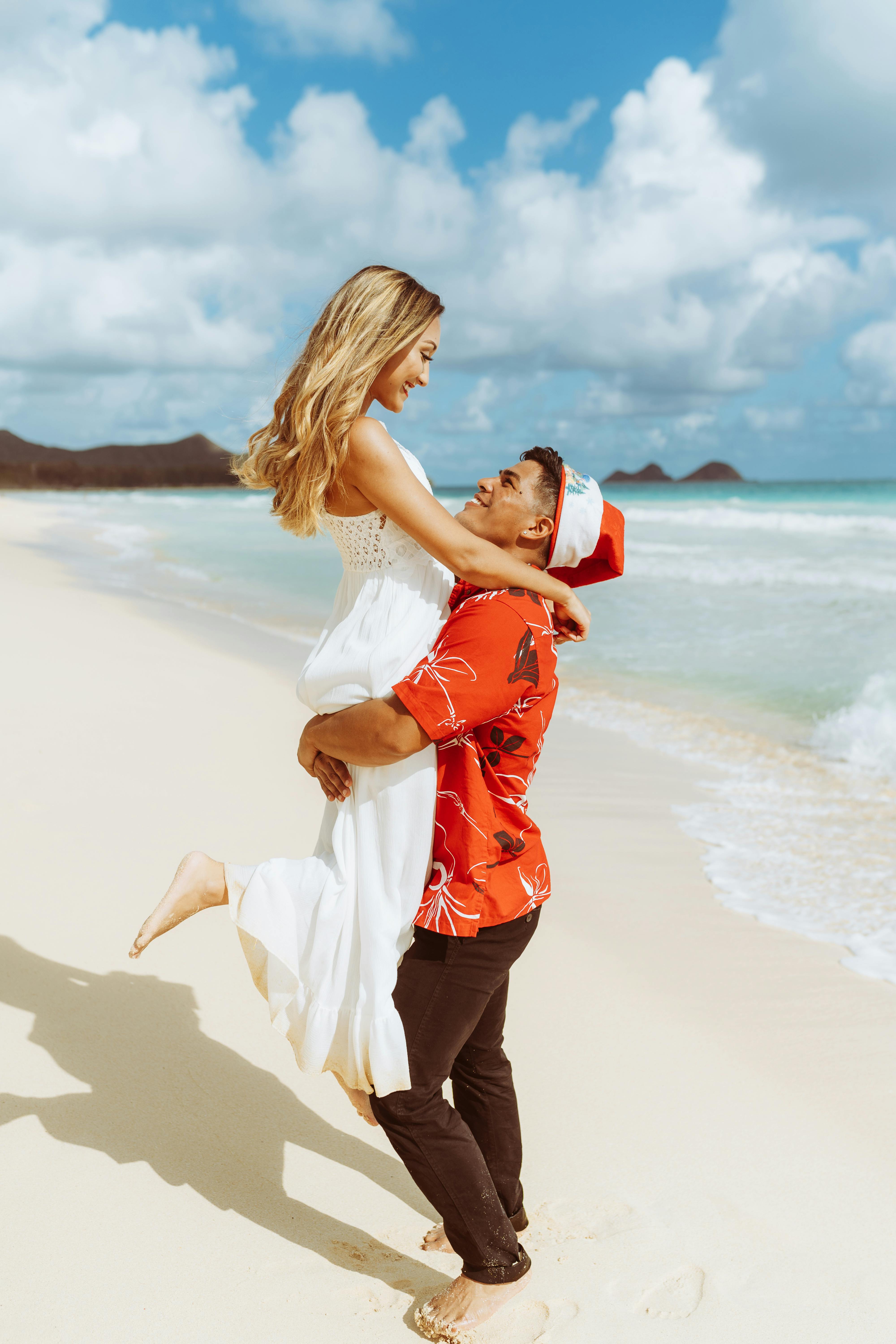 a man carrying a woman on the beach