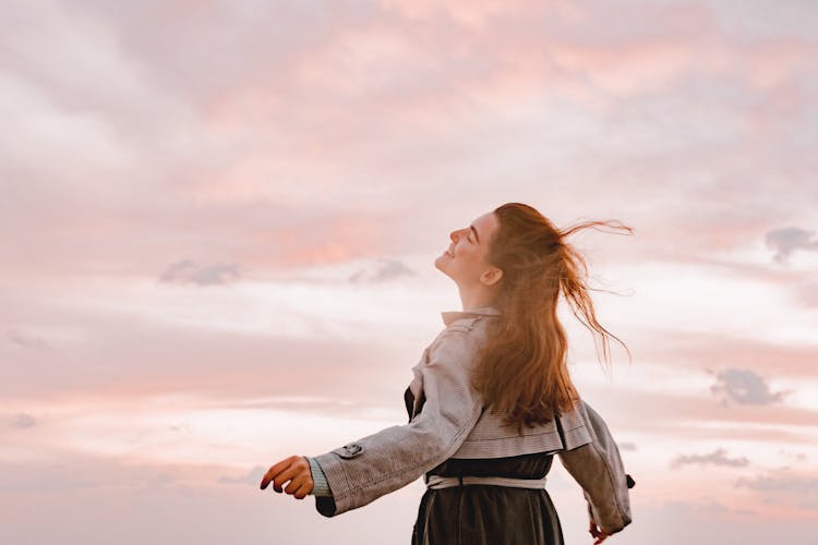 Happy Woman Smiling, Spreading Her Arms And Facing The Sky 