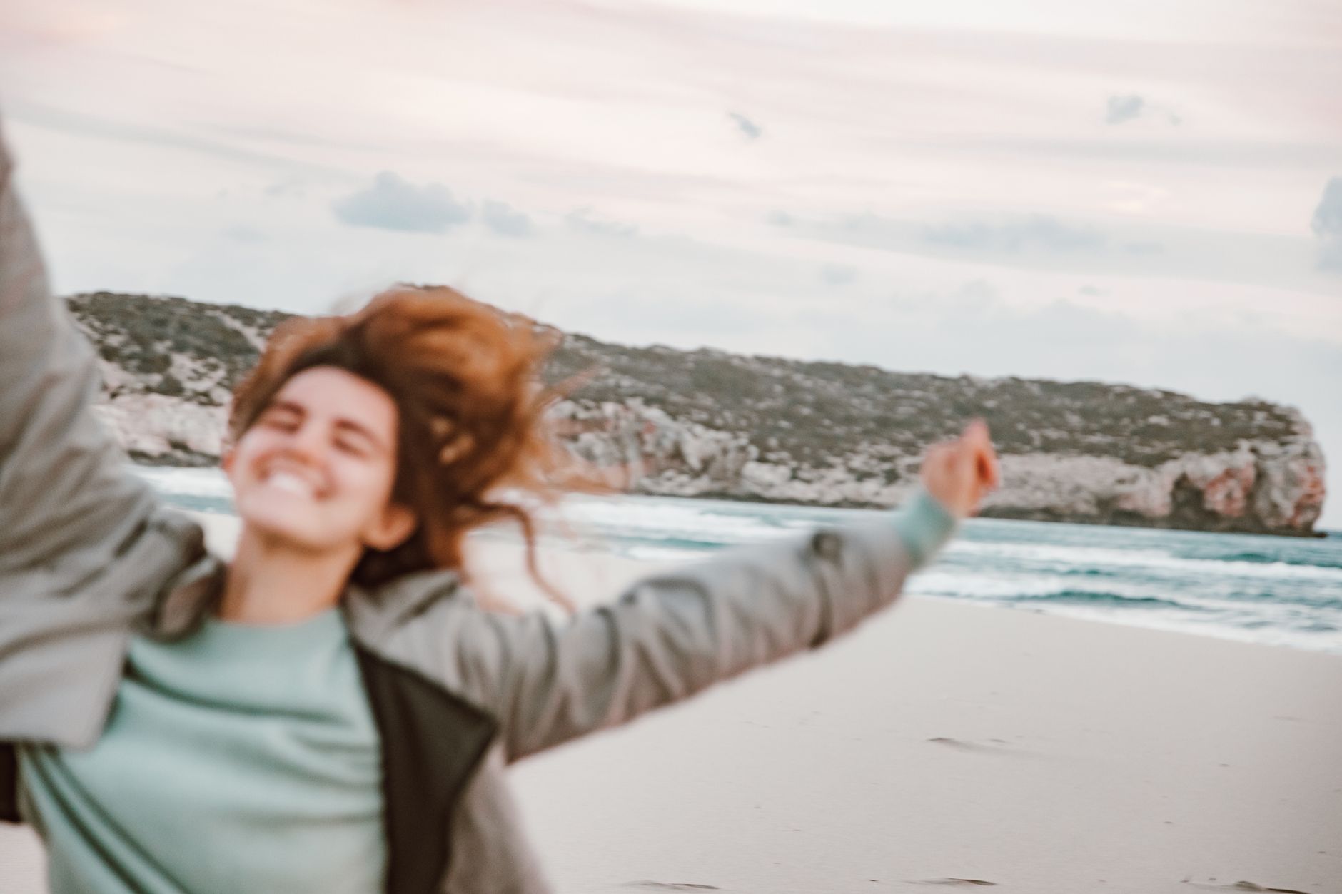 An energetic young woman enjoying a carefree day on a beautiful scenic beach.