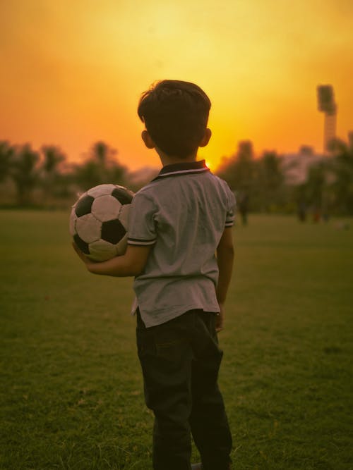 Free A Boy Holding a Football Stock Photo