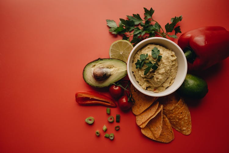 A Guacamole Dip On Red Surface