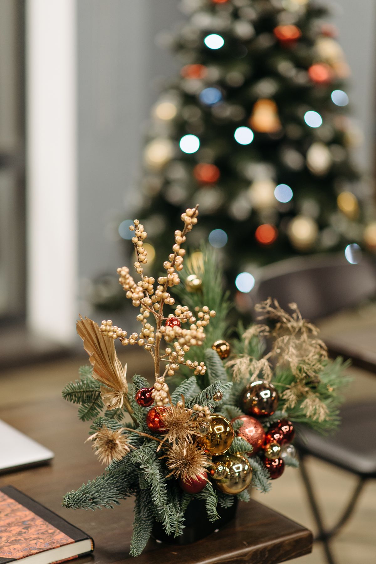 Christmas centerpiece ideas with a decorated Christmas table centerpiece and tree in the background
