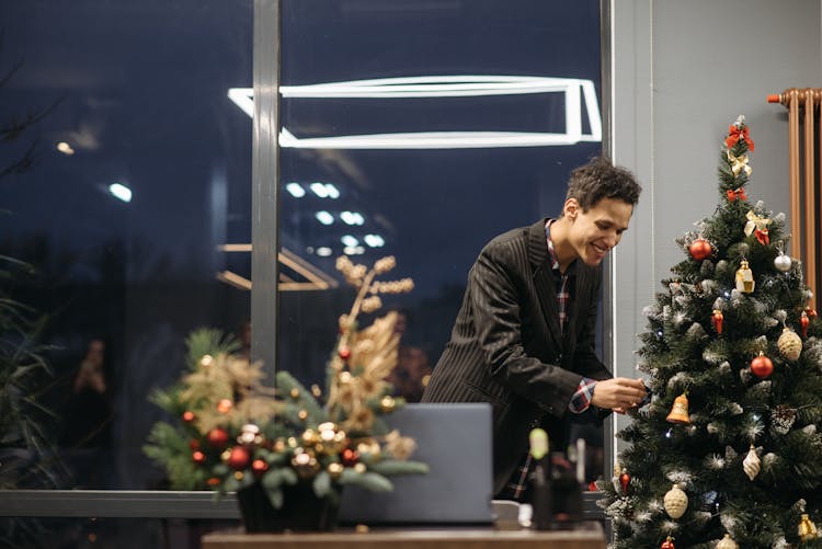 Photo Of A Man Decorating A Christmas Tree