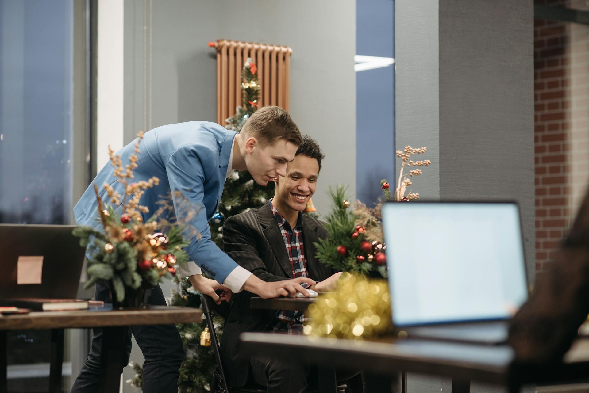 Colleagues celebrating in an office with Christmas decorations and cheerful atmosphere.