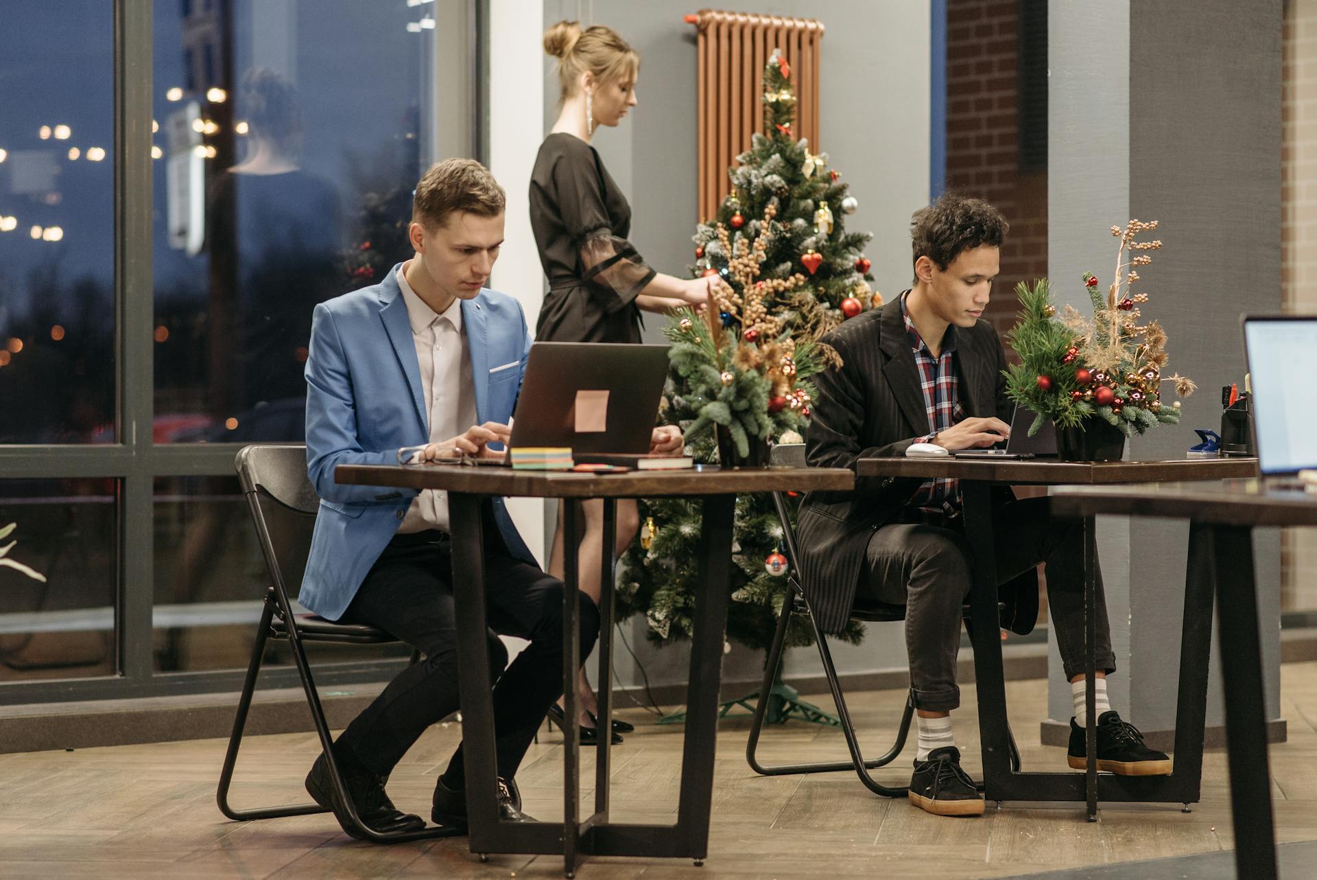 Office workers engaging in tasks amidst festive Christmas decorations and a holiday atmosphere.