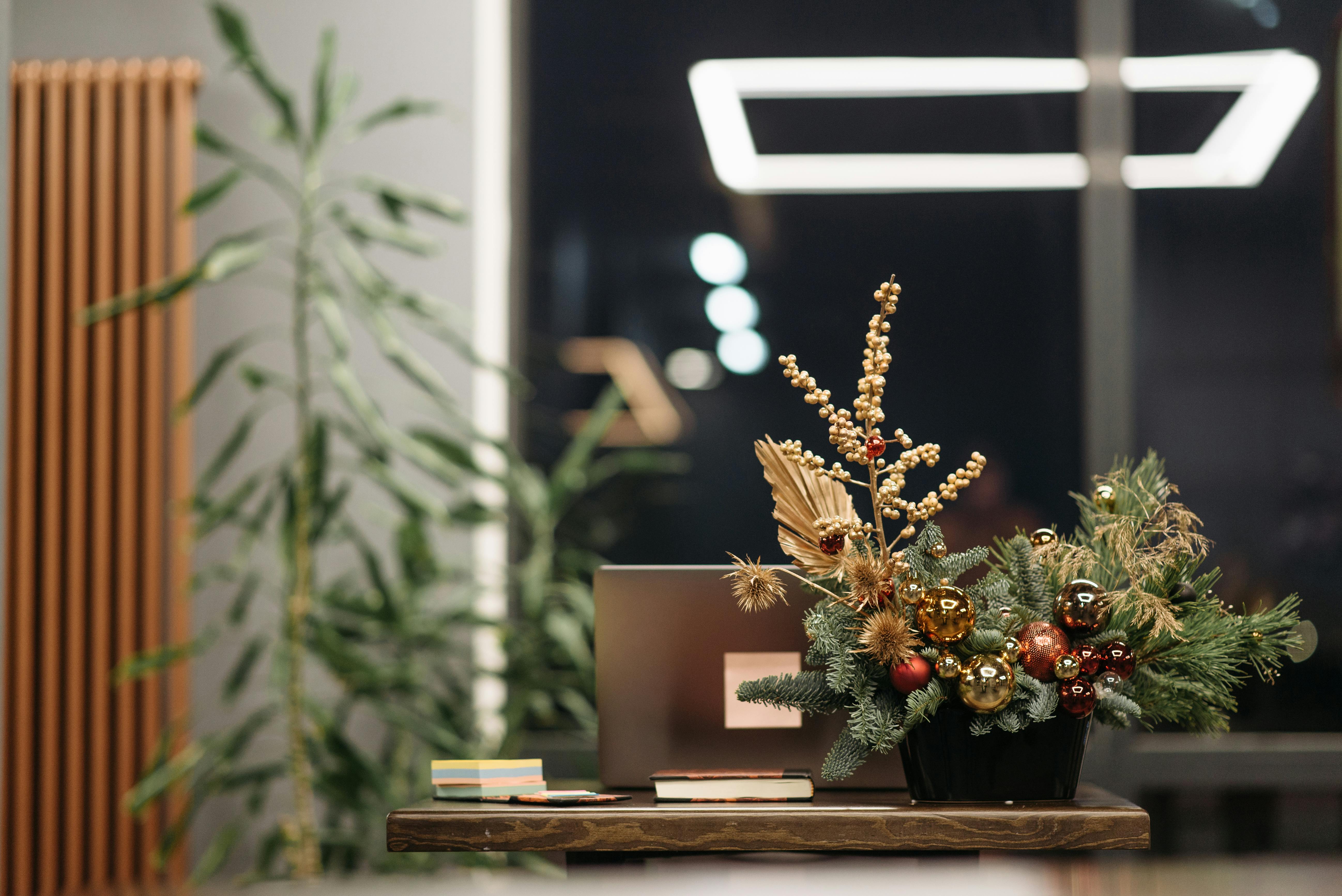 A modern office workspace decorated with a festive Christmas floral arrangement.