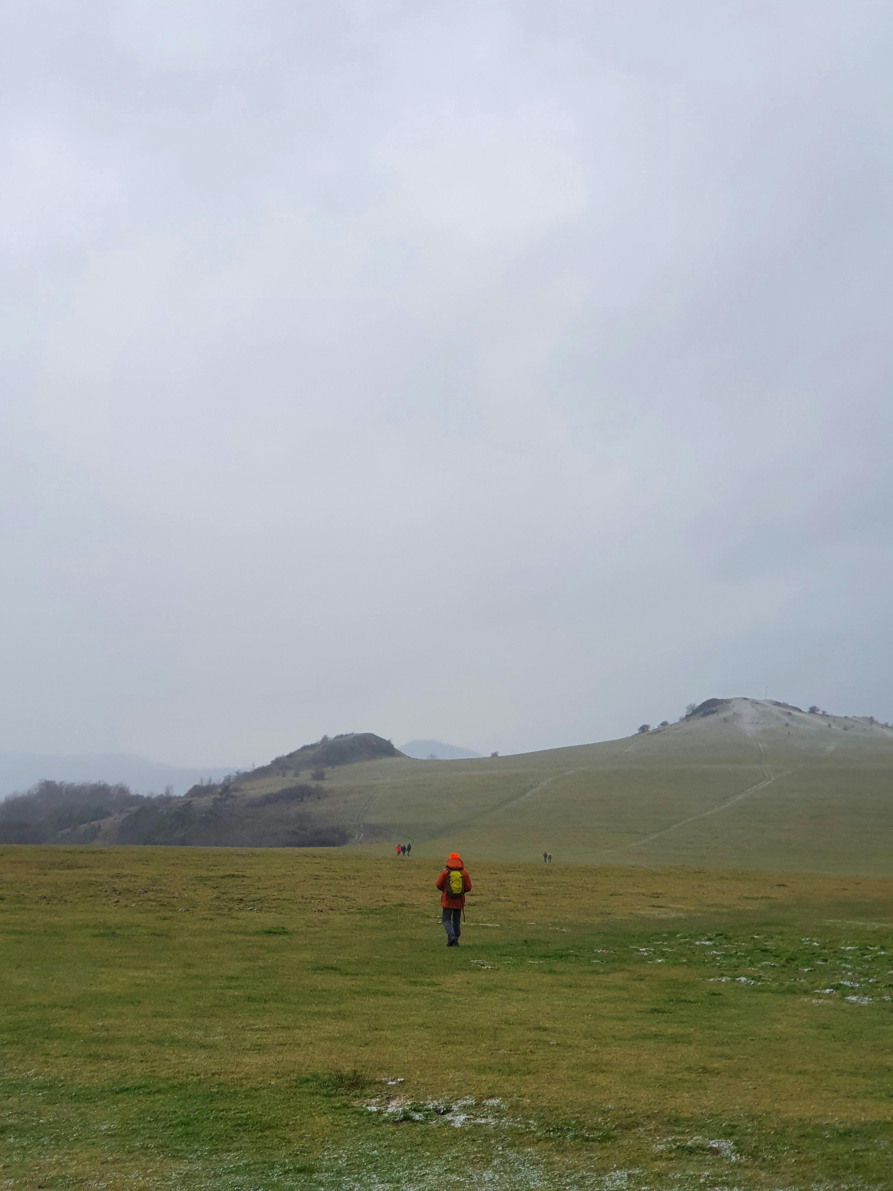 A lone hiker walks through a misty meadow in Zierenberg, Germany, capturing serene natural beauty.