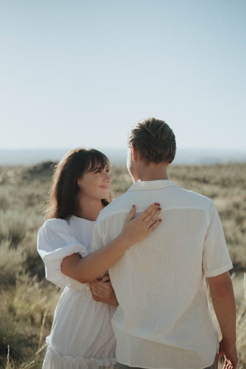 Happy woman hugging boyfriend in field