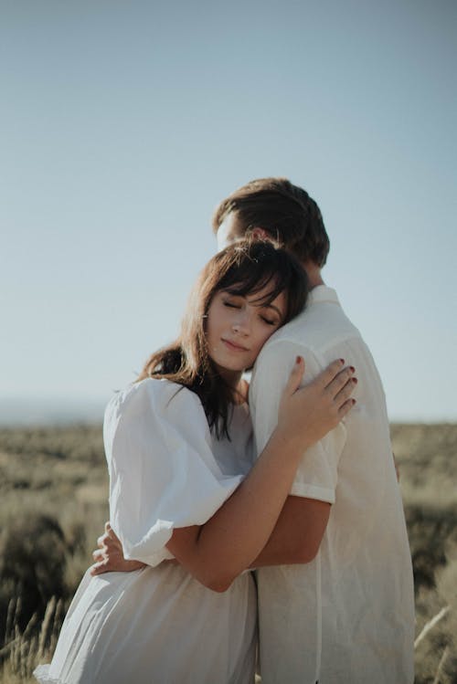 Young couple hugging in rural field