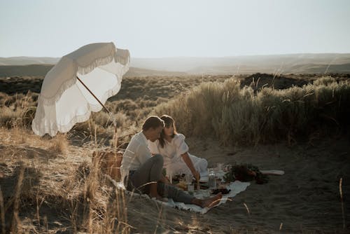 Young romantic couple having picnic on sandy beach
