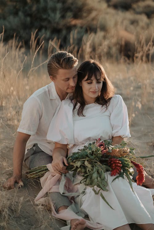 Young loving couple enjoying romantic date in rural meadow in summer