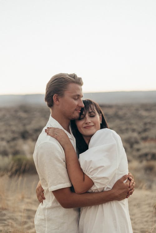 Happy couple embracing gently in grassy field in savanna