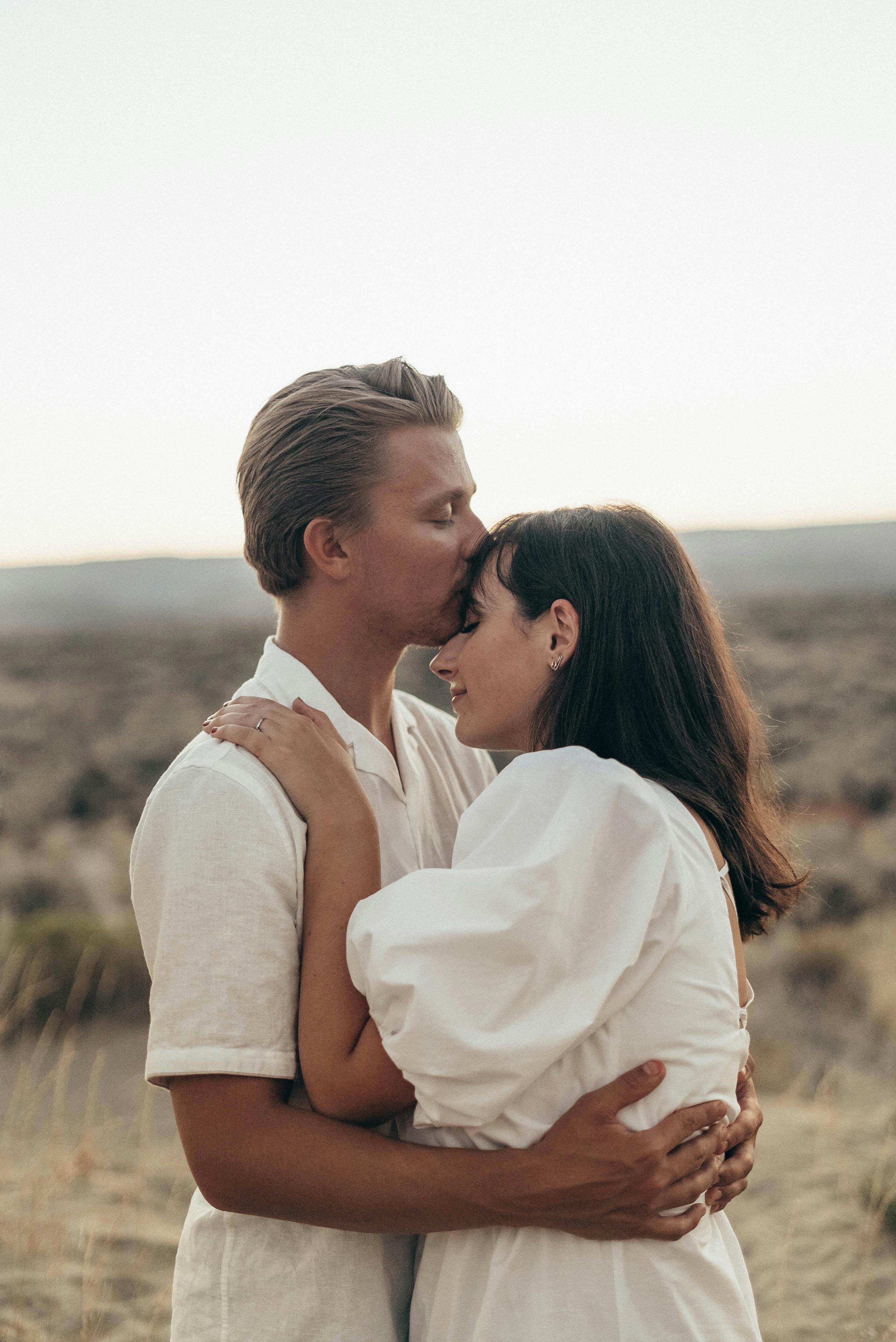 romantic couple with closed eyes embracing in field