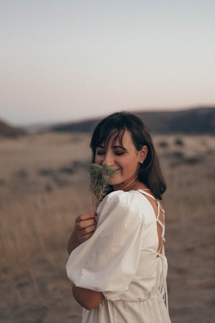 Stylish Cheerful Woman With Dried Plant Standing In Field